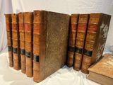 Plusieurs vieux livres sont alignés sur une nappe blanche