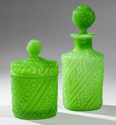 two green glass jars sitting next to each other on a white surface
