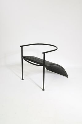 une image représentant un banc noir avec une assise incurvée