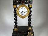 une horloge noire et dorée posée sur une table blanche