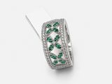 a close up of a diamond and emerald ring on a white background
