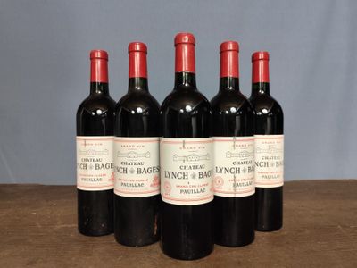 four bottles of red wine are lined up on a table