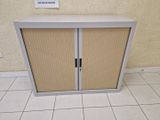 une armoire blanche à deux portes et une pancarte accrochée au mur