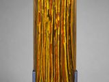 sculpture représentant un bouquet de bâtonnets jaunes et orange posés sur un socle métallique