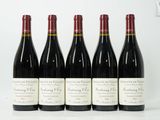 six bouteilles de vin sont alignées sur une table