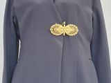 an image of a woman ' s coat with a gold broochet on it