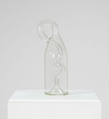 une sculpture en verre représentant une femme dans une bouteille en verre posée sur un socle