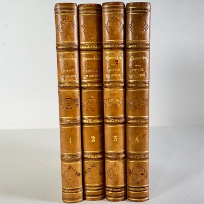 four old books are stacked on top of each other on a white surface