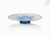 un bol en verre avec un socle bleu posé sur une surface blanche