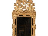 un miroir doré surmonté d'un oiseau