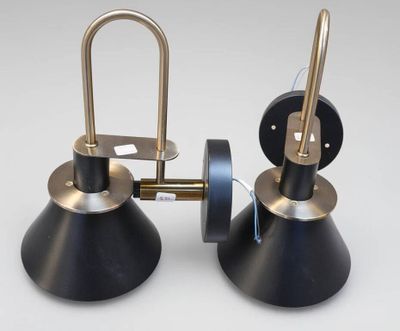 une paire de lampes noires et dorées posées sur une surface blanche