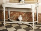 a white table with a mirror and a vase on it
