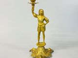brass figurine of a man holding a bird on a pedestal