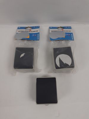 quatre morceaux de plastique posés sur une surface blanche, avec un téléphone portable