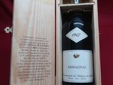 une bouteille de vin dans un coffret en bois posé sur une nappe rouge