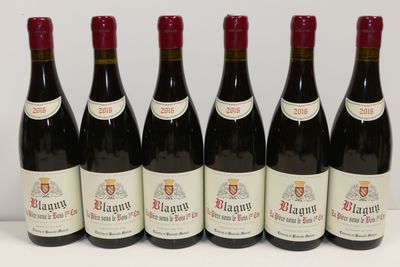 six bouteilles de vin rouge sont alignées sur une table