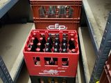 a red crate of soda sitting on a shelf in a store