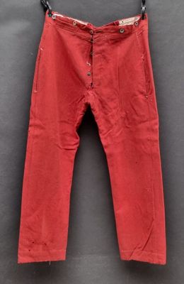 un pantalon rouge suspendu à un cintre accroché au mur