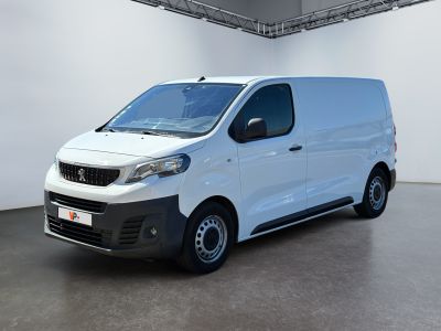 La camionnette blanche est garée dans une grande pièce.
