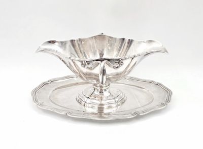 a silver plate with a flower on it on a white background