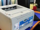 a printer sitting on a desk in front of a computer