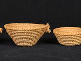 three small woven baskets are lined up against a black background
