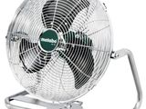 Gros plan sur un ventilateur métallique posé sur un pied, sur fond blanc