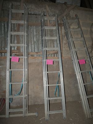 several metal ladders are lined up against a wall in a room