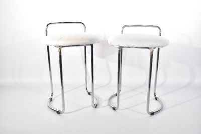 une paire de tabourets chromés et blancs à roulettes sur fond blanc