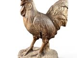 statue en bois représentant un coq posé sur un rocher, sur fond blanc