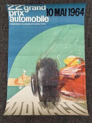 an old poster of a race car on display in a museum