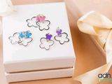 une boîte blanche sur laquelle figurent quatre papillons de couleurs différentes