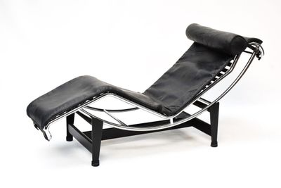 une chaise longue et un pouf en cuir noir sur fond blanc
