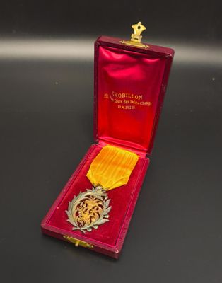 medal in a red case on a black surface with a gold ribbon