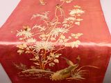 un chemin de table rouge orné d'oiseaux et de fleurs