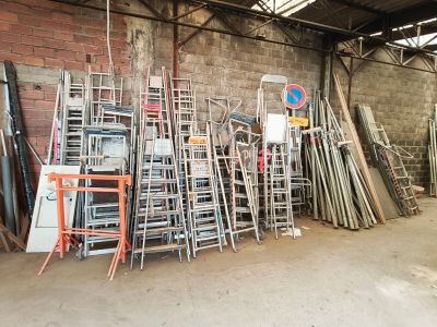 a lot of chairs and ladders in a warehouse