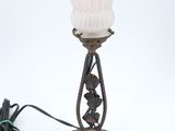 une lampe surmontée d'une fleur rose