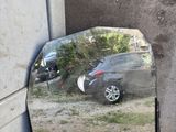 a mirror on the side of a building that has a car in it