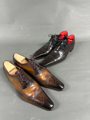 two pairs of brown shoes with red soles on a gray surface