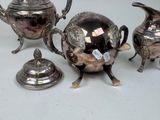 three silver teapots and a teapot on a table