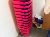a pink basket that is next to a trash can