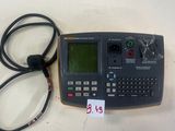une calculatrice posée sur une table à côté d'un cordon