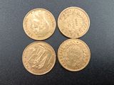 quatre types différents de pièces d'or sur une surface noire