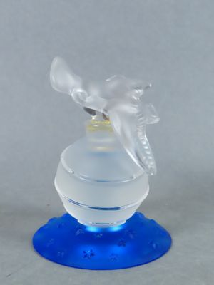 a clear glass bottle with a blue base and a bird on top