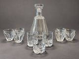 four glasses and a decanter sitting on a table