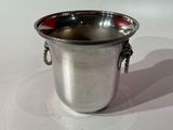 a silver cup that is sitting on a white surface