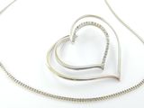 pendentif en forme de cœur en argent sterling, suspendu à une chaîne en argent, sur fond blanc