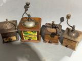 three old fashioned coffee grinders are lined up on a white surface
