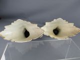 pair of white shell shaped vases on clear acrylic stand