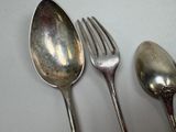 three spoons and a fork on a table